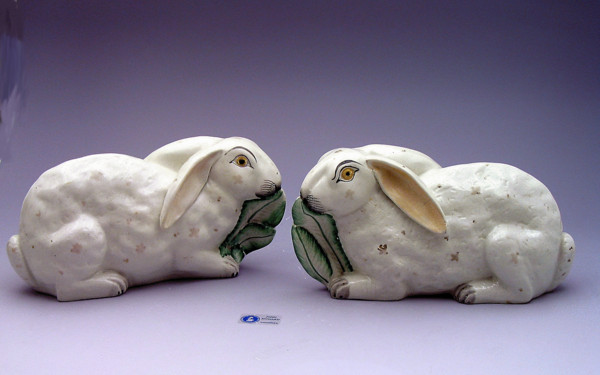 Pair Staffordshire pottery figures of rabbits munching on leaves.