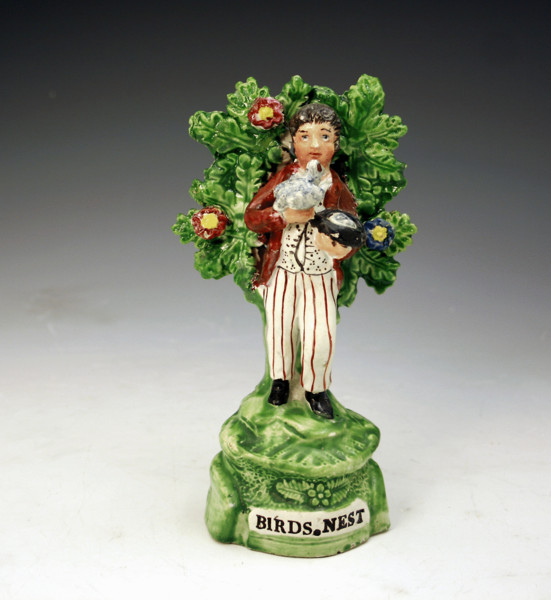ANTIQUE STAFFORDSHIRE PEARLWAE FIGURE OF BIRDNESTER WITH BOCAGE.