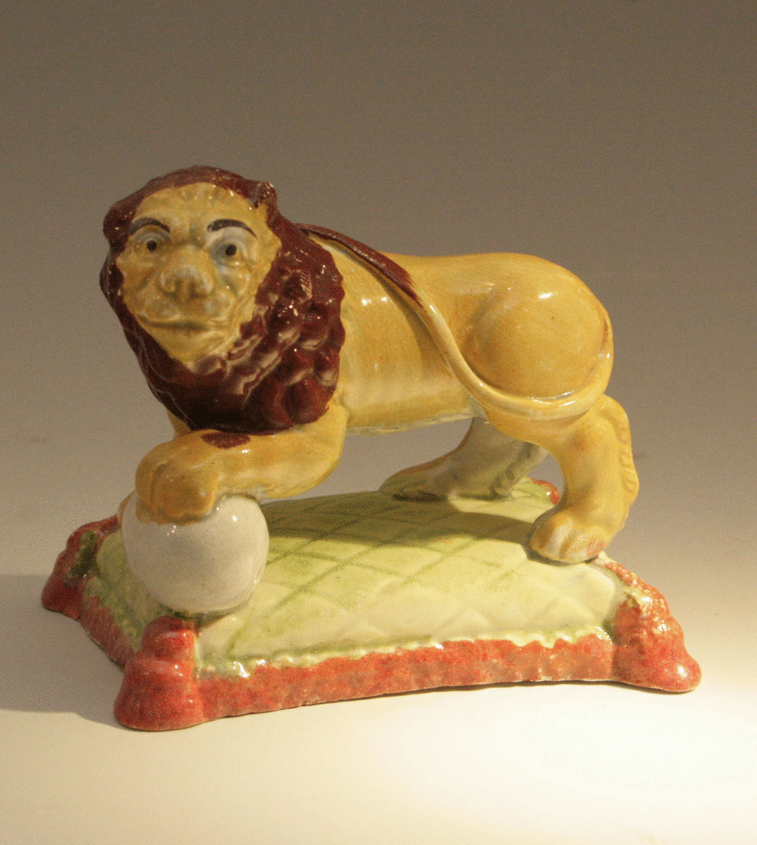 Antique Staffordshire pottery standing lion on base..... early 19thc