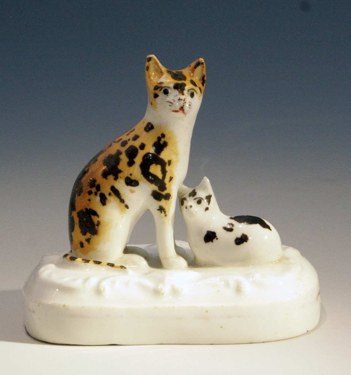 Antique ceramic Staffordshire figure of a calico cat with kitten 19thc