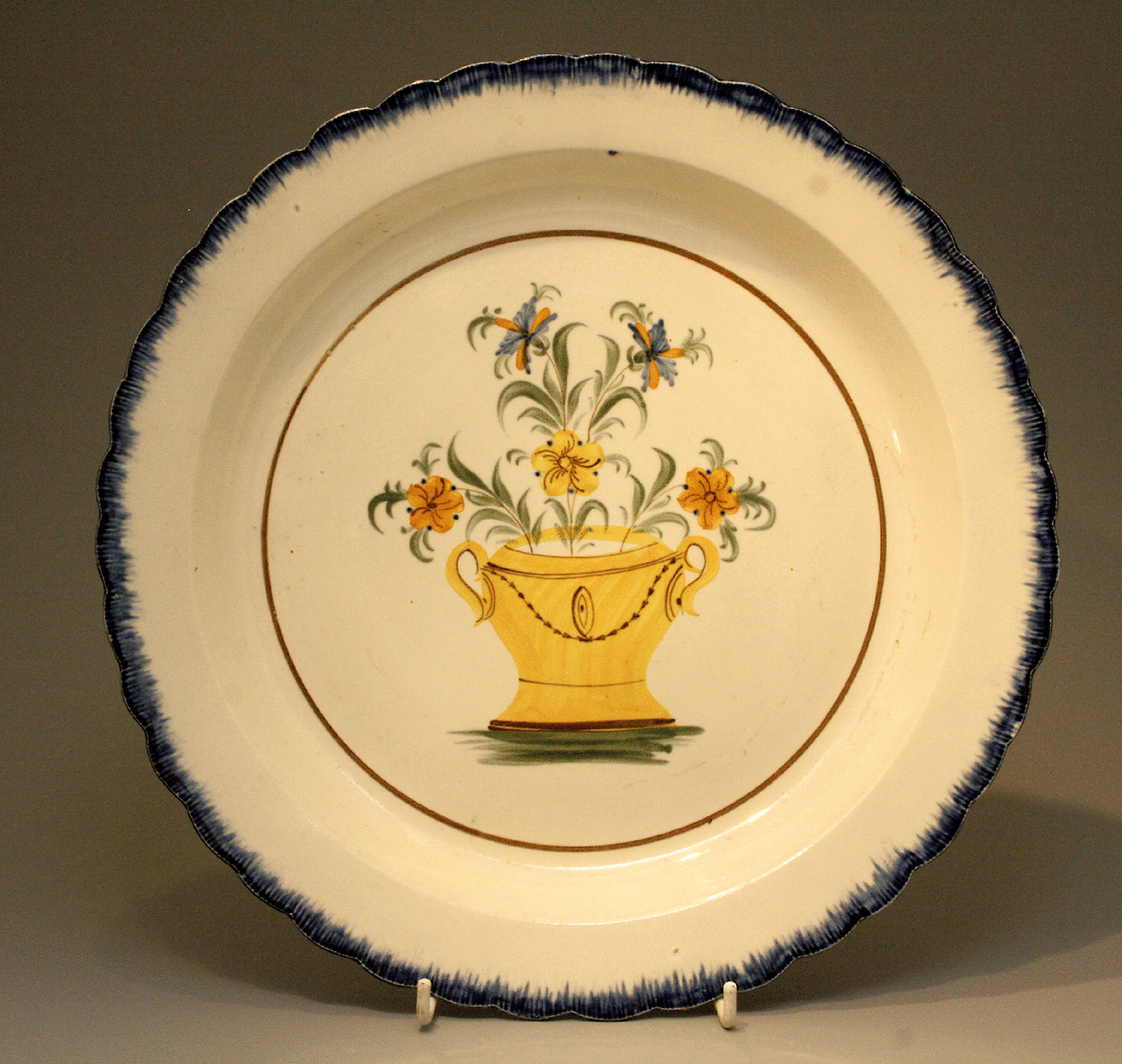 Antique pottery Pearlware Charger with basket of flowers in center panel.