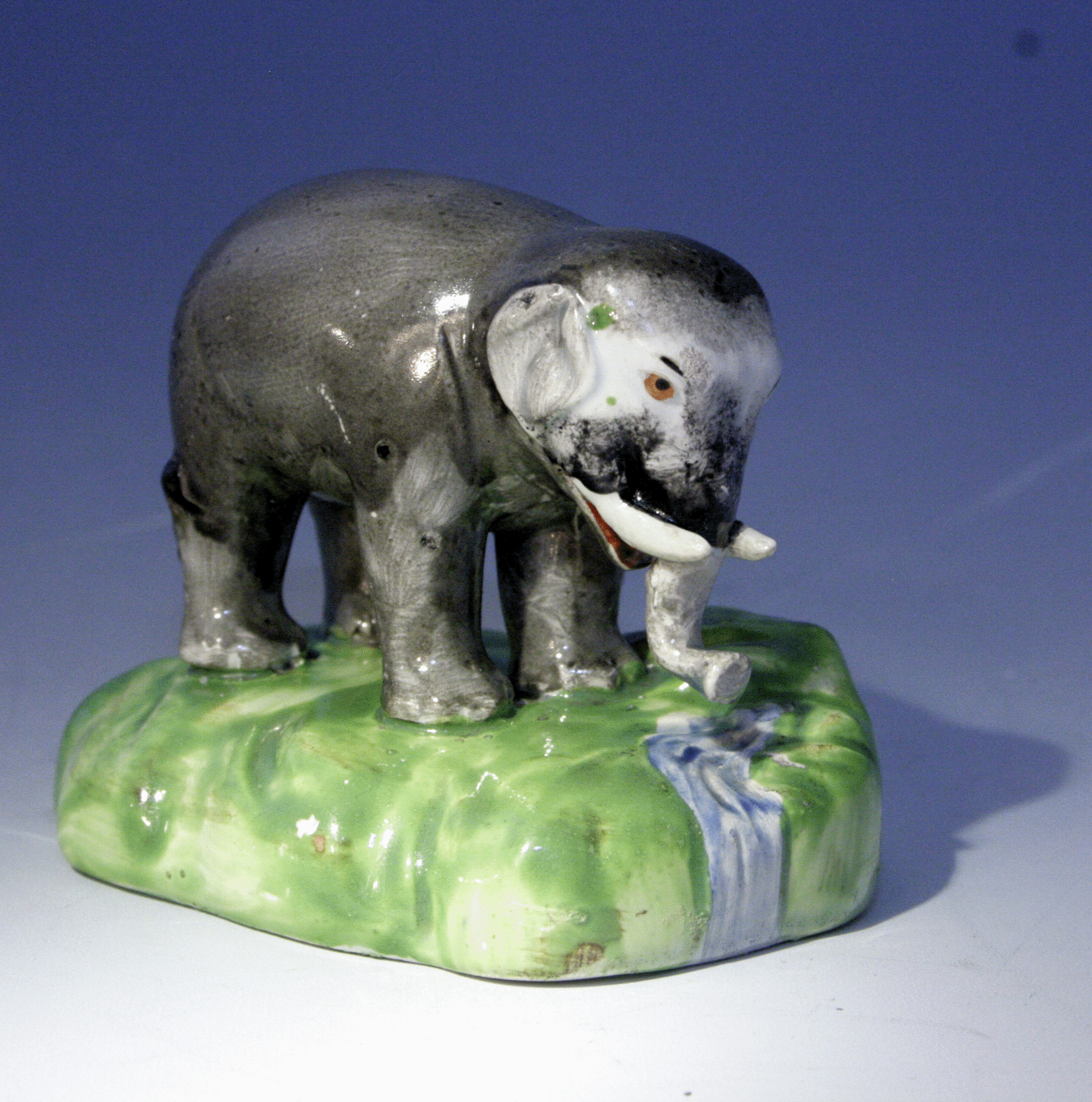 Staffordshire figure of an elephant by a stream