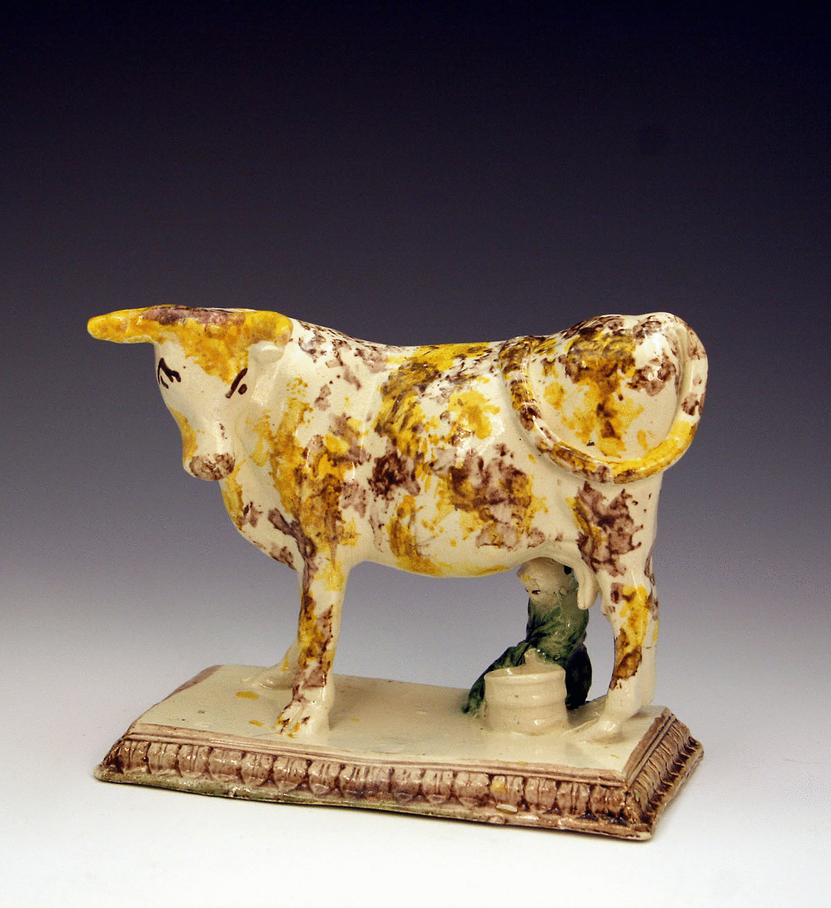 ANTIQUE ENGLISH POTTERY FIGURE OF A COW ON BASE