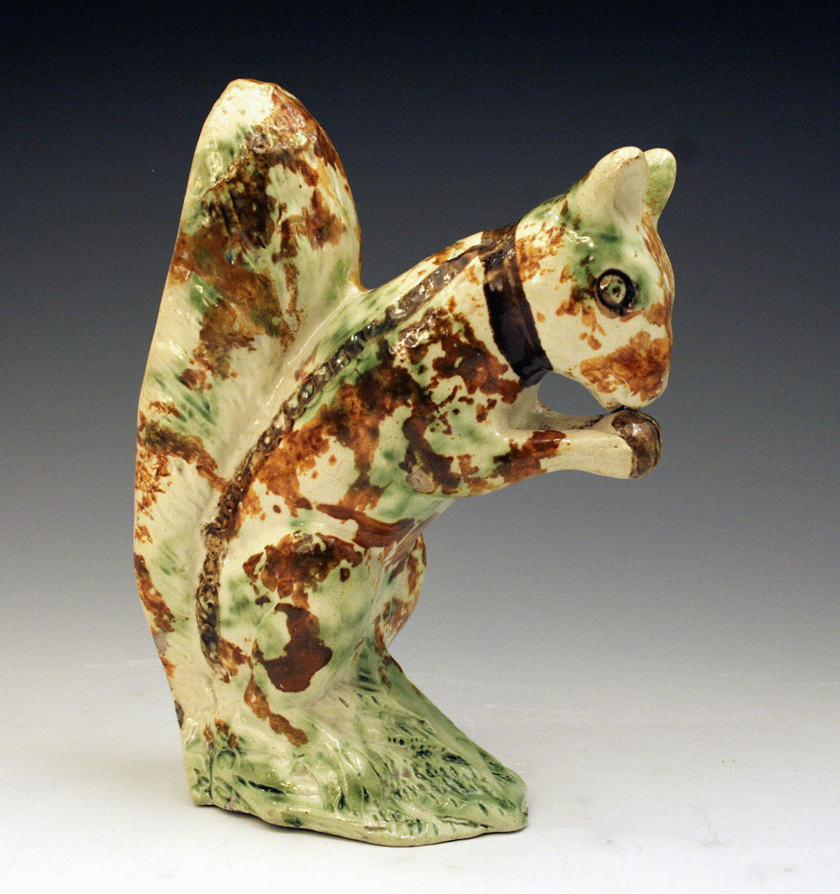 STAFFORDSHIRE  POTTERY FIGURE OF SQUIRRELL IN UNDERGLAZE COLOURS