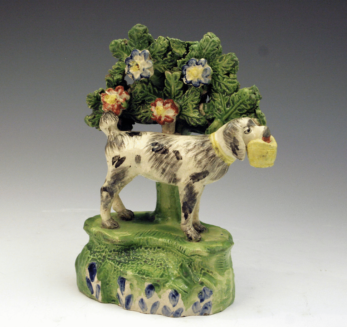 STAFFORDSHIRE FIGURE OF A DOG HOLDING A BAG IN HIS MOUTH