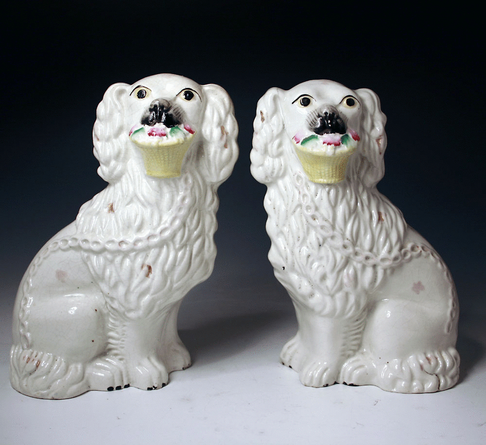 Pair antique figures of Staffordshire pottery dogs with baskets