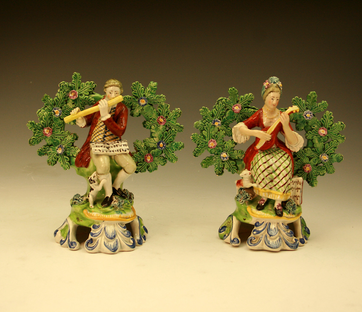 Pair of Staffordshire pottery figures of musicians with bocage