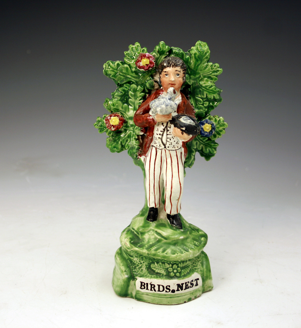ANTIQUE STAFFORDSHIRE PEARLWAE FIGURE OF BIRDNESTER WITH BOCAGE.