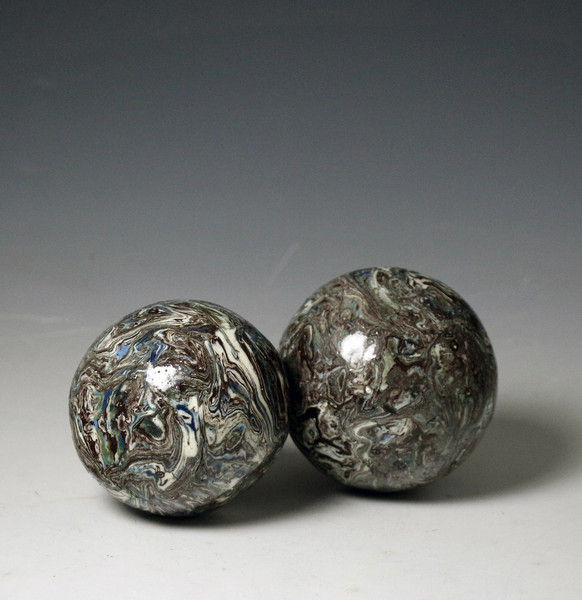 Two variegated agateware pottery balls 