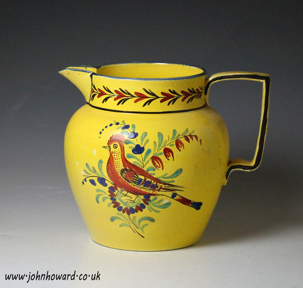 Antique English pottery yellow ground pitcher with figure of bird in foliage, early 19th century