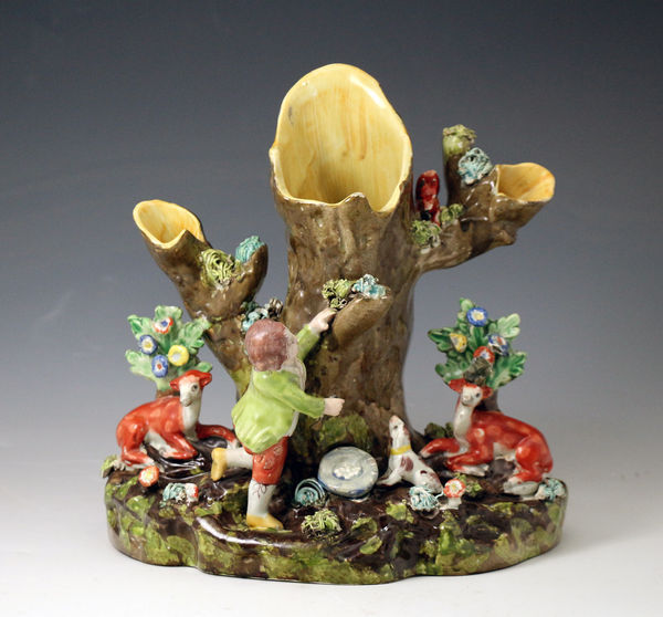 Antique Staffordshire pottery tree trunk group with boy nesting and stag and doe with bocage. c1820