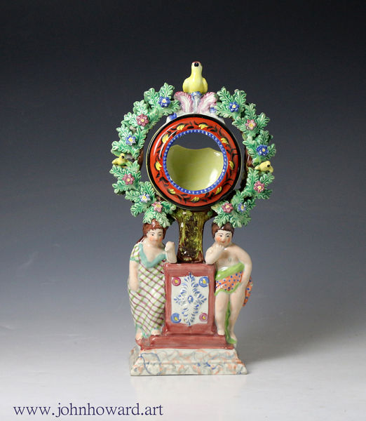 Staffordshire Pottery figure group watch holder with two cherubs standing against a plinth.circa 1820