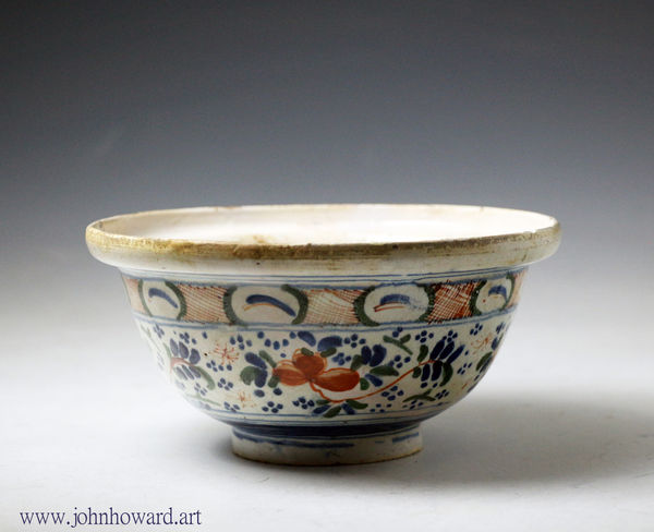 London delftware butter bowl polychrome colours and a spike at base, early 18th century England