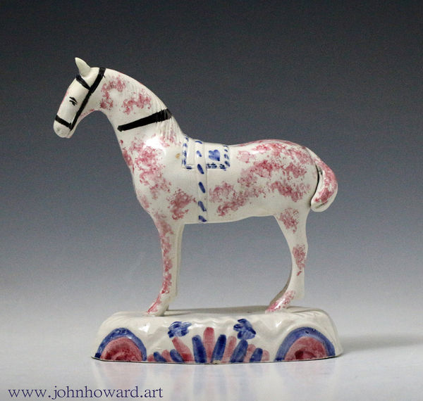 Early pottery figure of a horse standing on an unusual oval base. British circa 1800