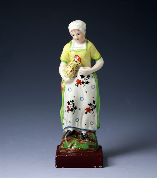 Staffordshire pottery figure pearlware of a girl holding a hen. early 19thc England