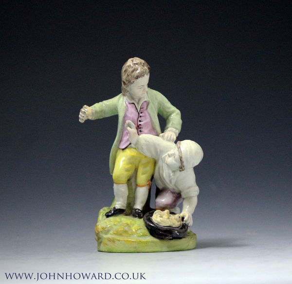 Staffordshire pottery figure group of two children scuffling over a birds nest. Antique period early 19th century