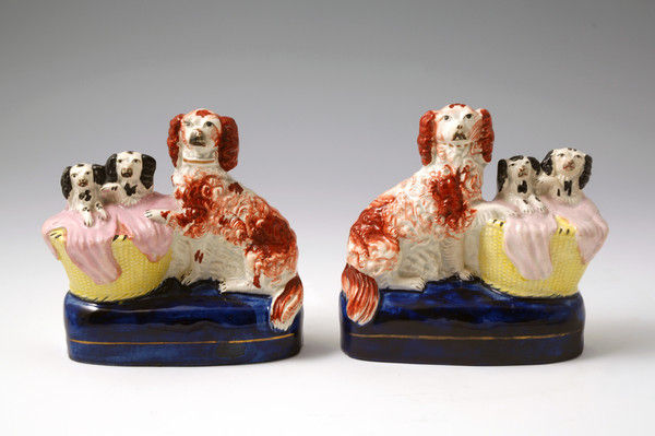 Pair Staffordshire pottery dogs with pups in  basket with blankets c1850