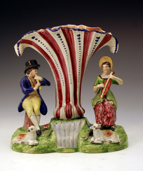 Staffordshire pottery figure group of musical shepherds by a stream