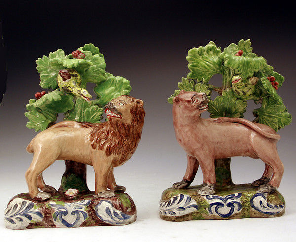 Pair of Staffordshire pottery figures of a lion and lioness against bocage