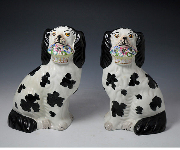 Pair of antique Staffordshire pottery figures of spaniel dogs with baskets mid 19th century.