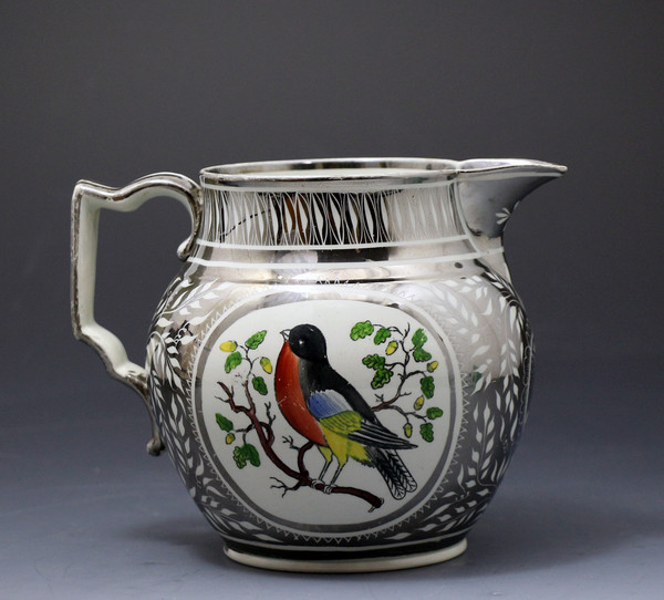 Antique pottery pitcher in silver luster with image of a robin circa 1820