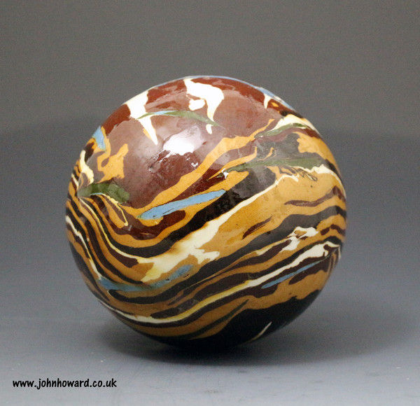 Agateware pottery ball mocha coloured  variagated slip surface decorated .Early 19thc English
