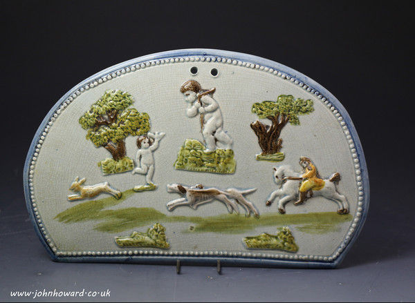 Antique Prattware English pottery plaque with applied images of rural sports and cherubs 18th century period