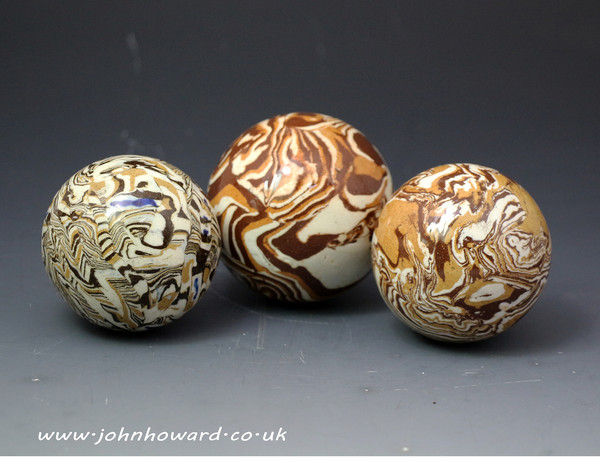 Three antique English pottery agateware balls late 18th century