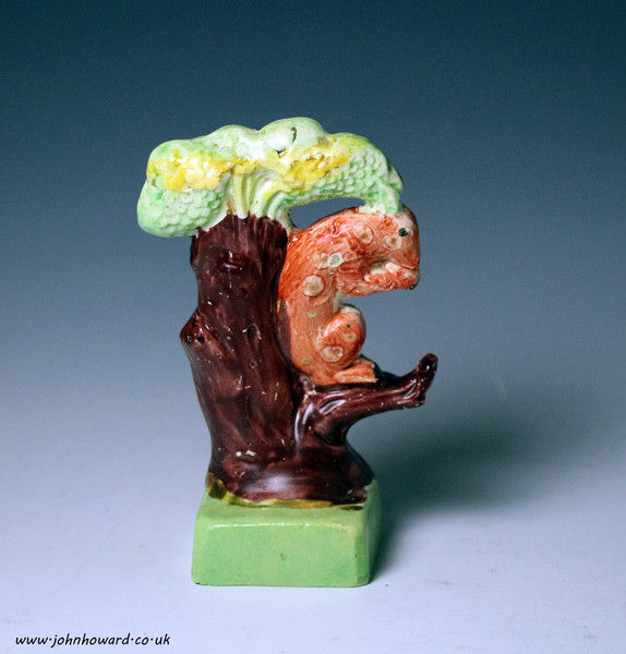Antique Staffordshire pottery pearlware figure of a squirrel seated on branch early 19th century