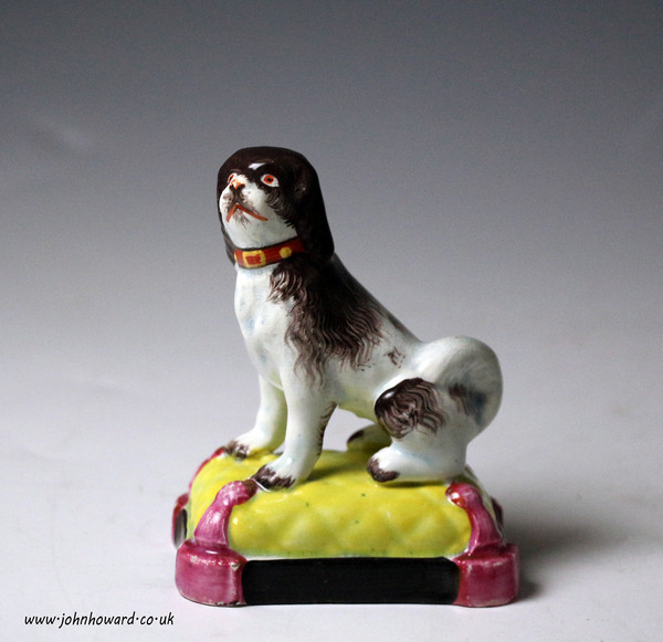 Staffordshire pottery pearlware figure of a dog seated on cushion base. antique period early 19th century