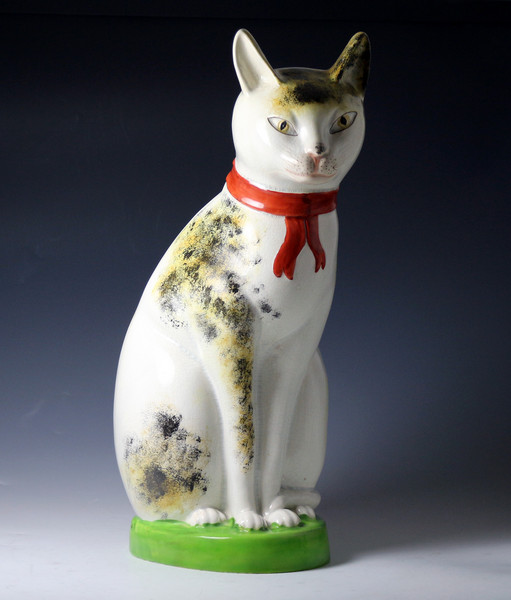 Large scale Staffordshire pottery figure of a seated cat with a knowing smile  circa 1835