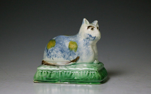 Staffordshire pottery pearlware figure of a cat lying on cushion early 19th century