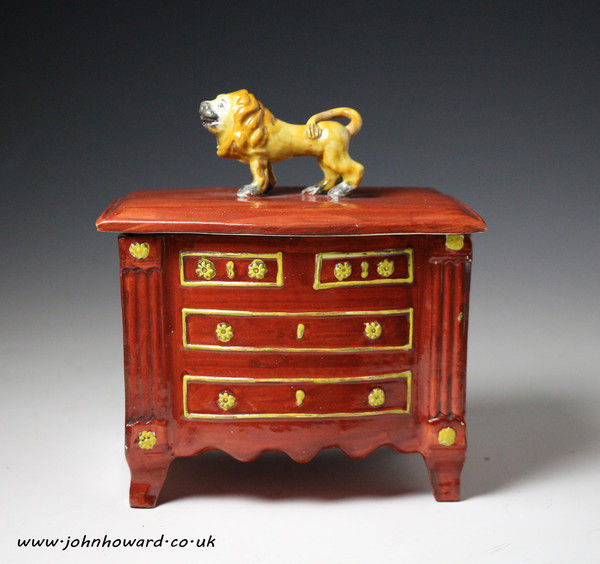Staffordshire pottery pearlware box in the form of a chest of drawers with lion finial on cover, early 19th century period.