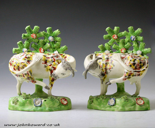 Pair of Staffordshire pottery figures of cows on bases with bocage pearlware English antique period early 19thc.