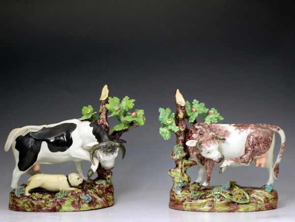 Pair of antique Staffordshire pottery figures of cow and bull  with tree and bocage early 19th century English.