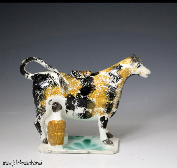 Antique English pottery cow creamer figure with milk maid figure early 19th century
