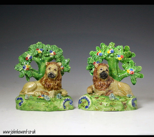 Pair antique Staffordshire pottery figures of lions with bocage marked Walton. early 19th century