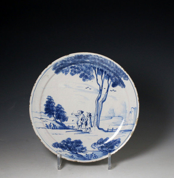 English delftware plate with scene of two figures in a rural landscape.  Lambeth London mid 18th century