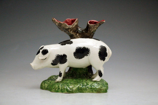 Antique pottery figure of a pig standing by tree trunk. Scottish early 19th century