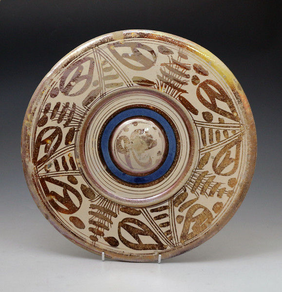 Early Hispano Moreque pottery charger decoarted with pink lustre and a blue band. C1650