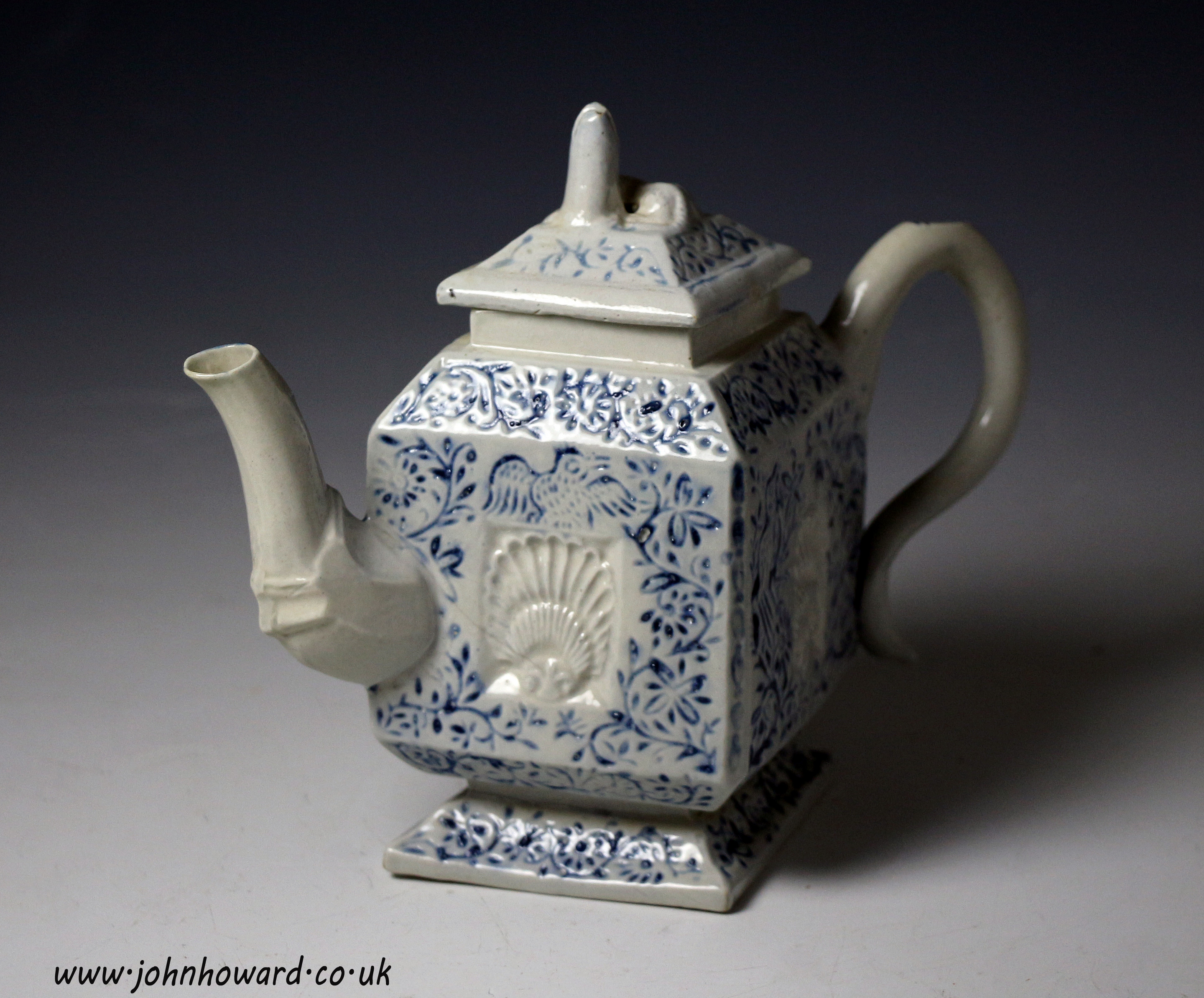 Antique Staffordshire pottery saltglaze teapot relief decorated in blue with shells foliage and birds mid 18th century