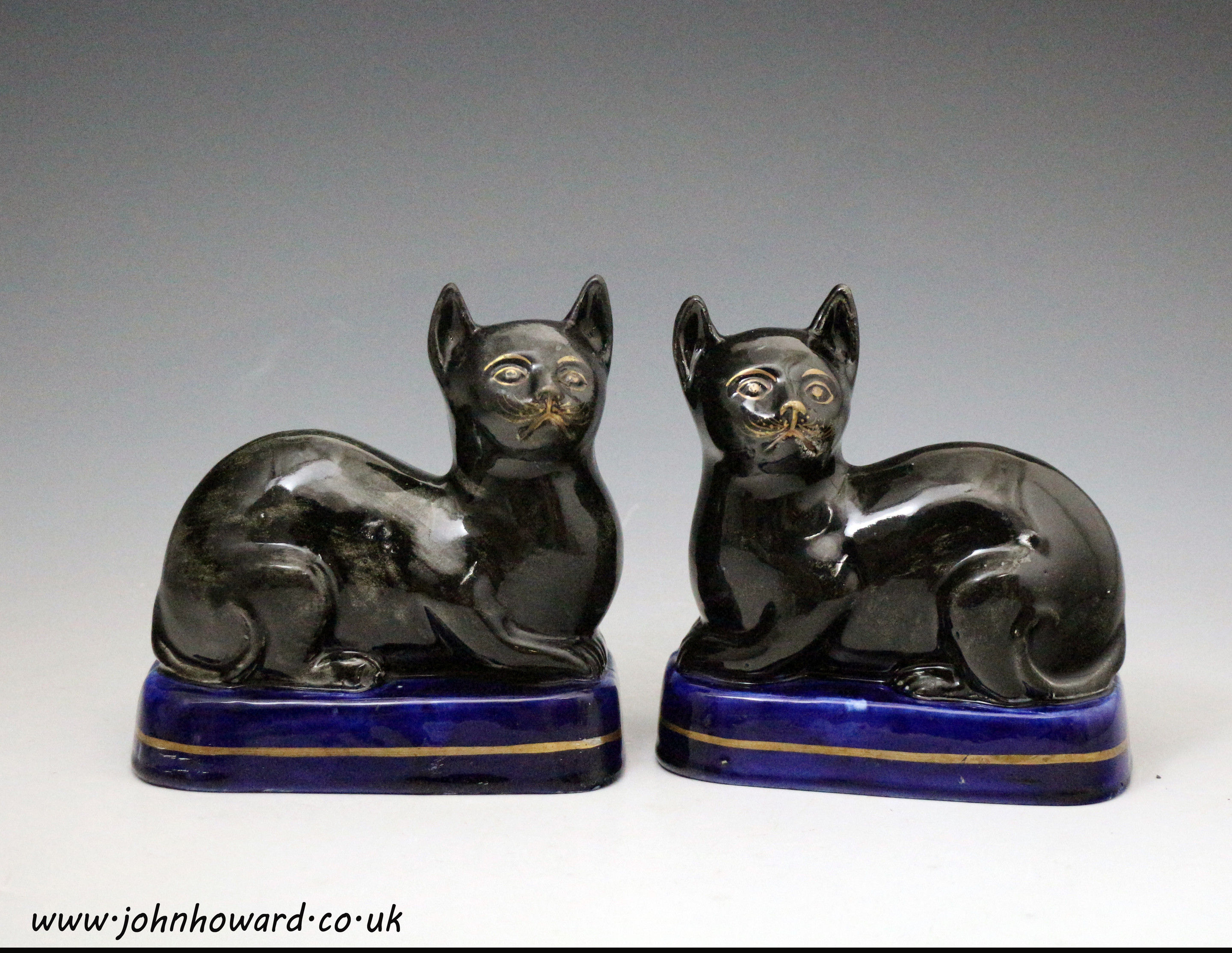 Antique Staffordshire pottery black cats on blue bases mid 19th century England.