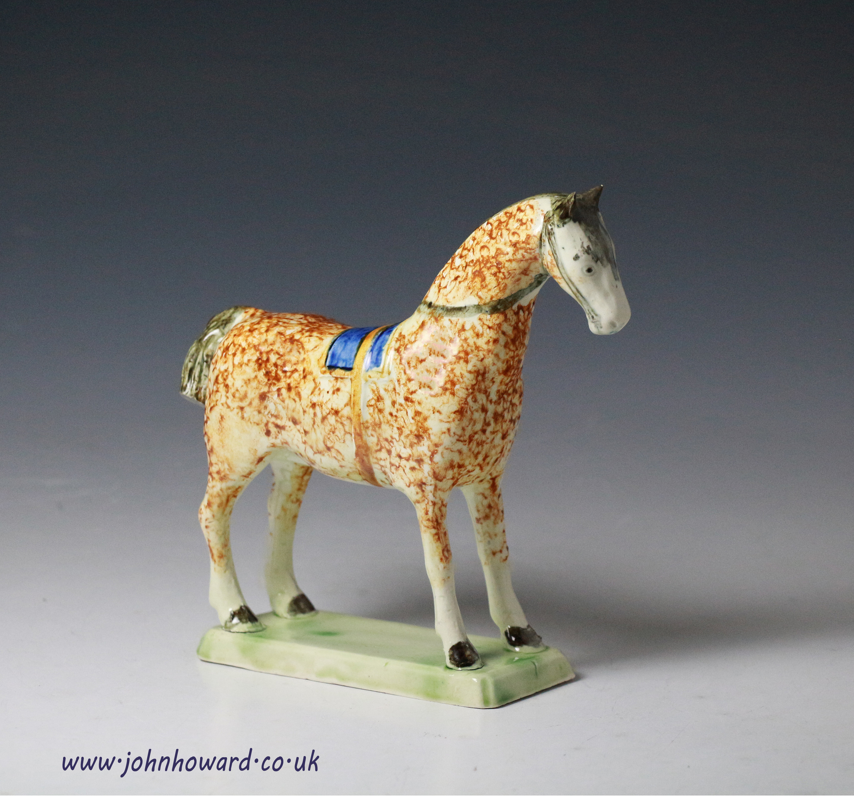 Antique English pottery figure of a horse standing on green base 