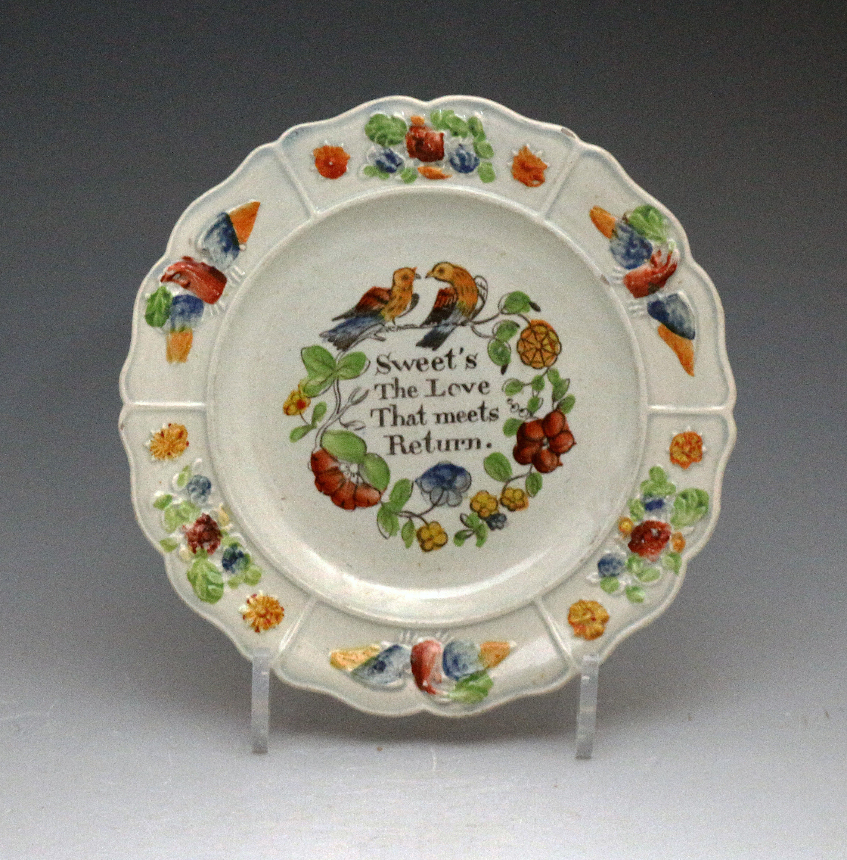 Antique pottery plate with birds and the legend Sweet's the love that meets return, Bristol or Swansea Pottery