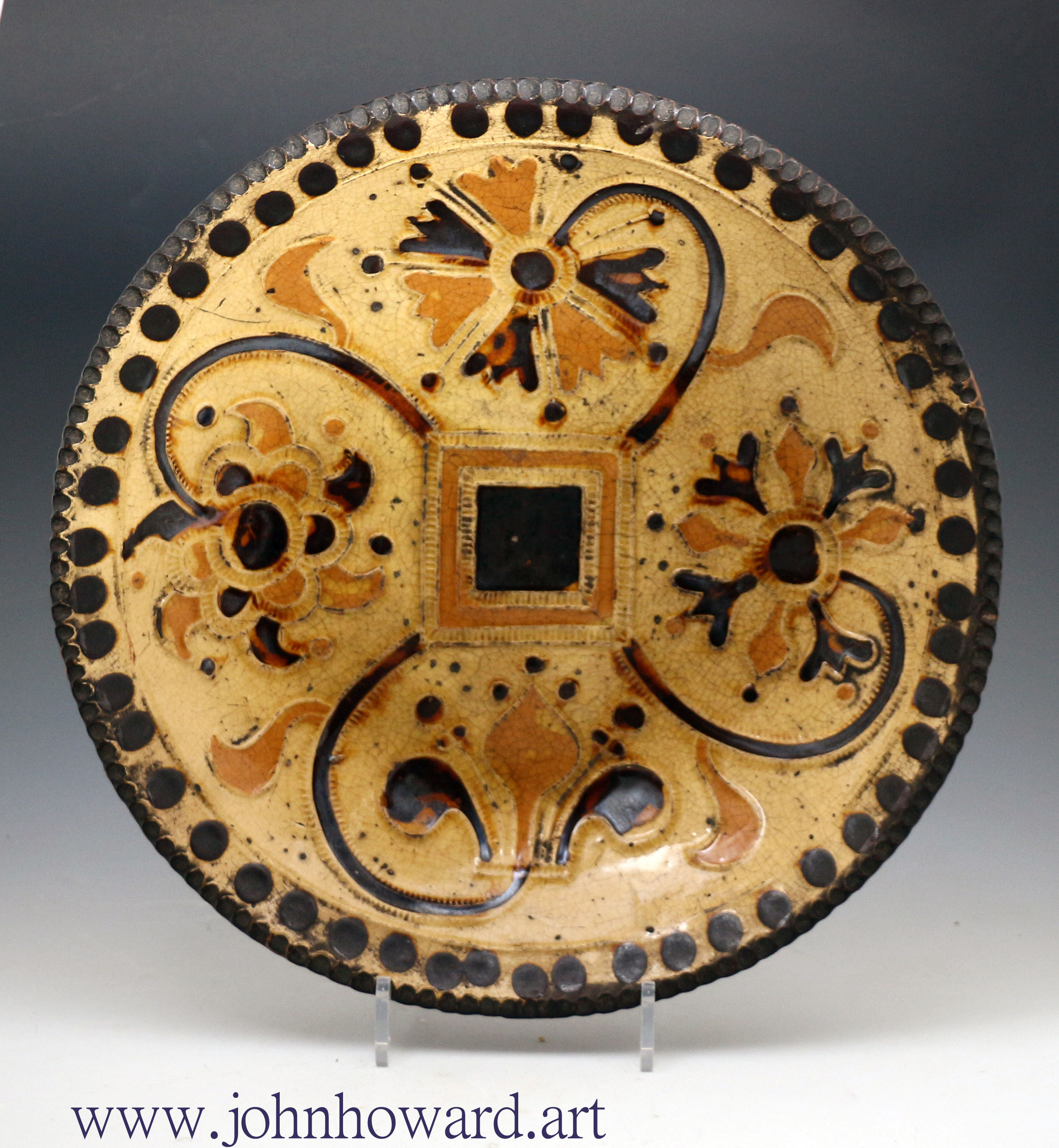 Slipware press moulded earthenware dish with geometric floral designs early 18th century Staffordshire .