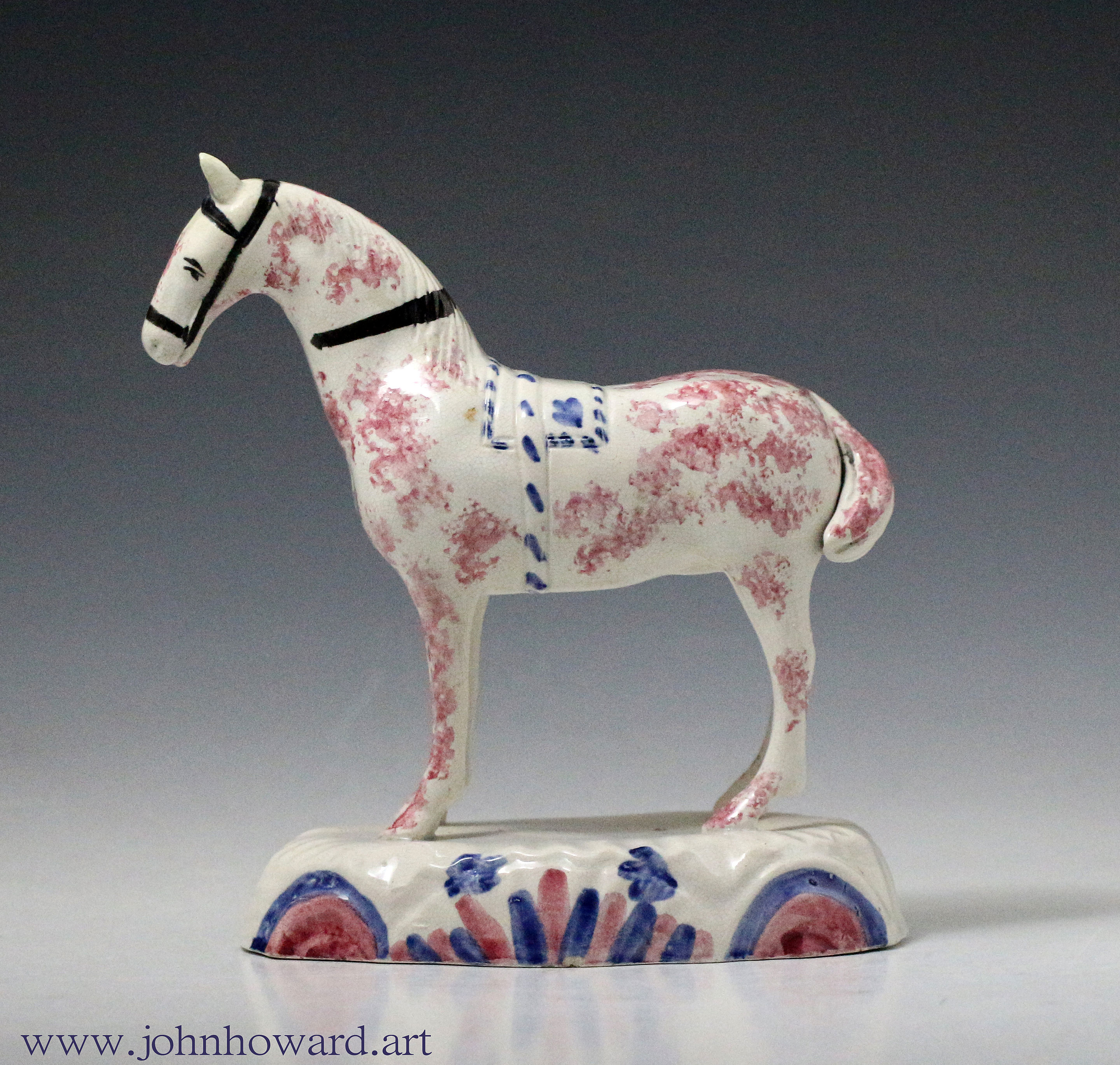 Early pottery figure of a horse standing on an unusual oval base. British circa 1800
