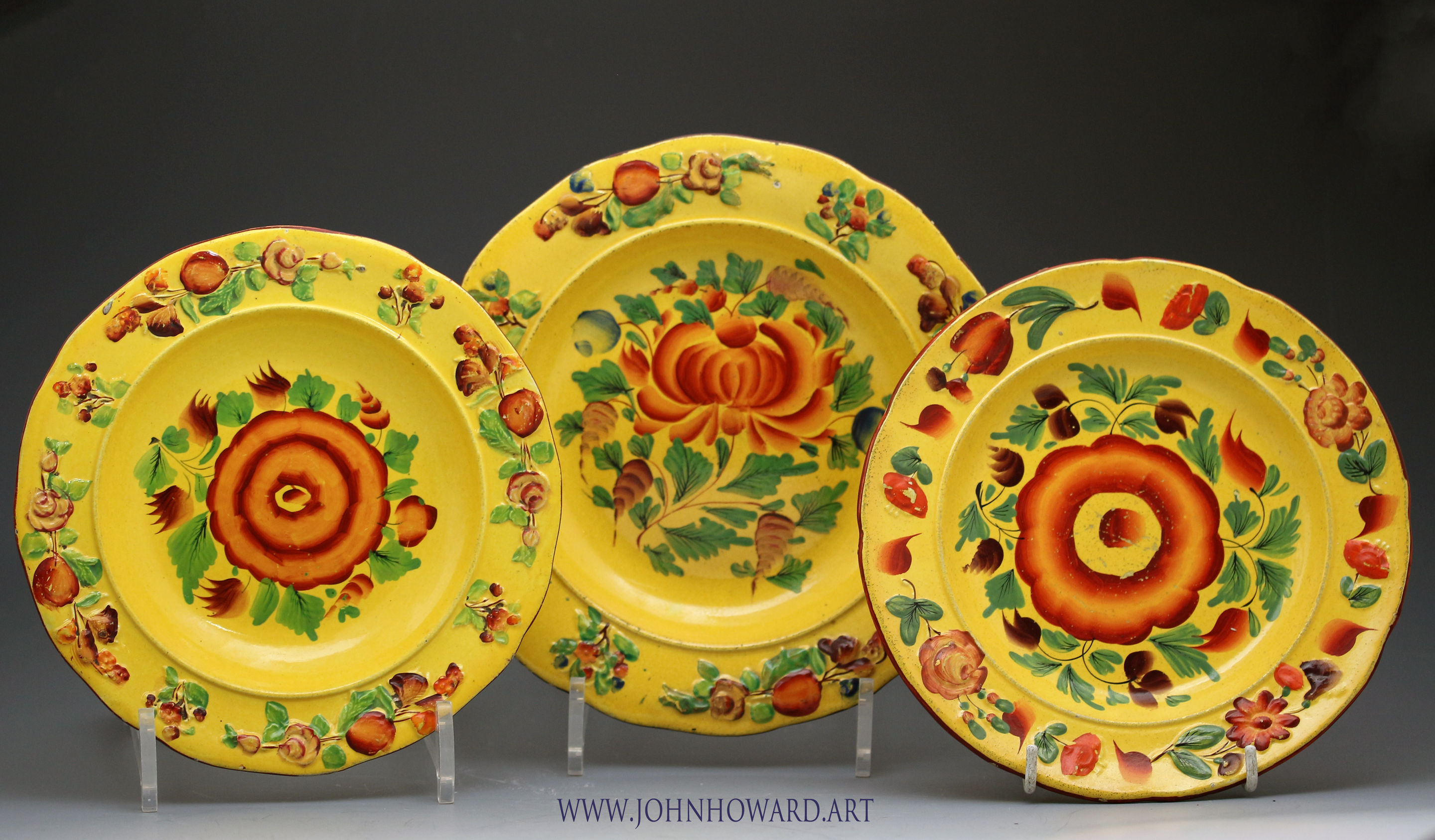 Trio of antique pottery plates with canary yellow ground and enamel colours early 19th century
