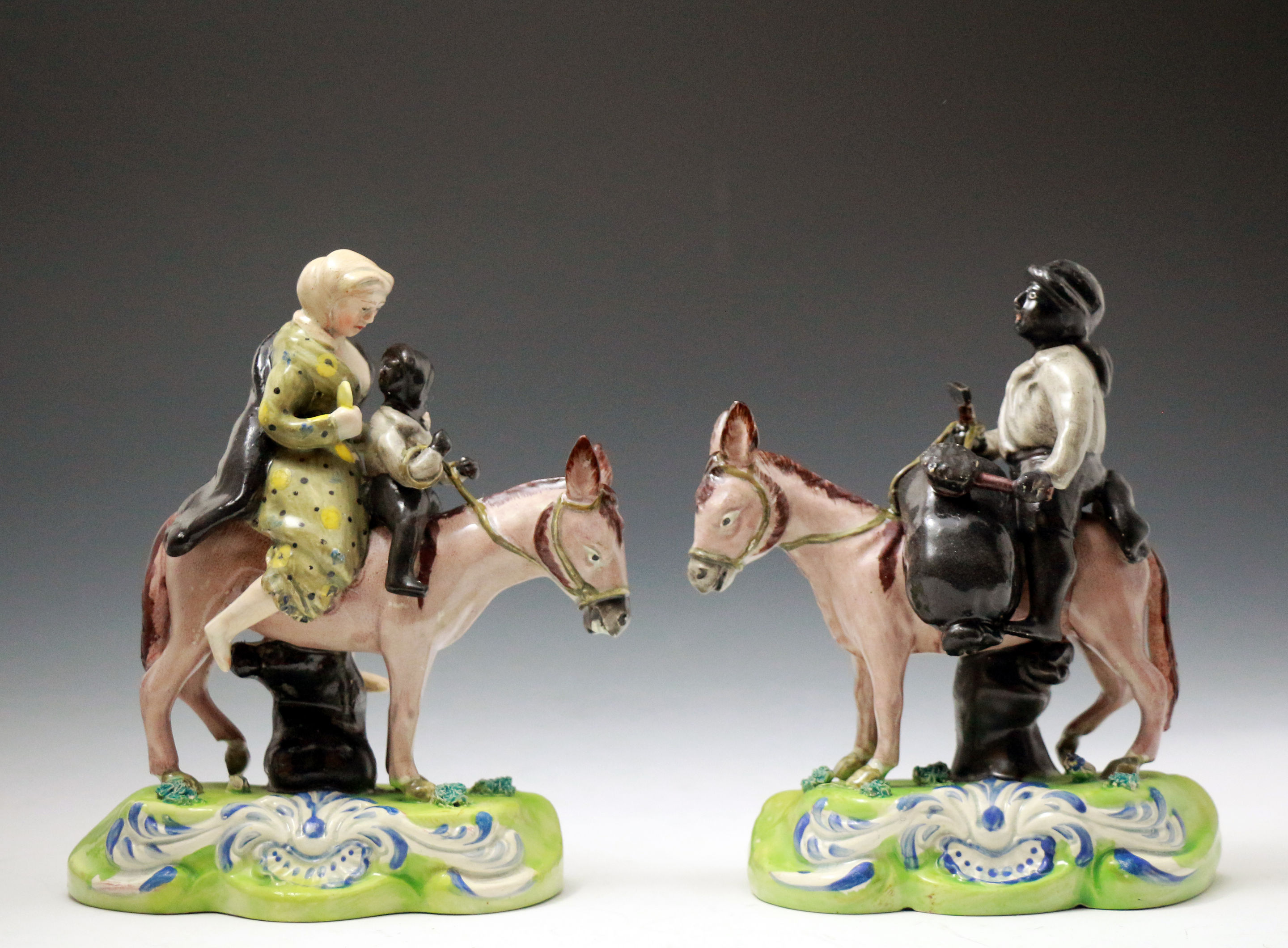 Pair Staffordshire pottery figures of chimney Sweep family riding mules.circa 1820