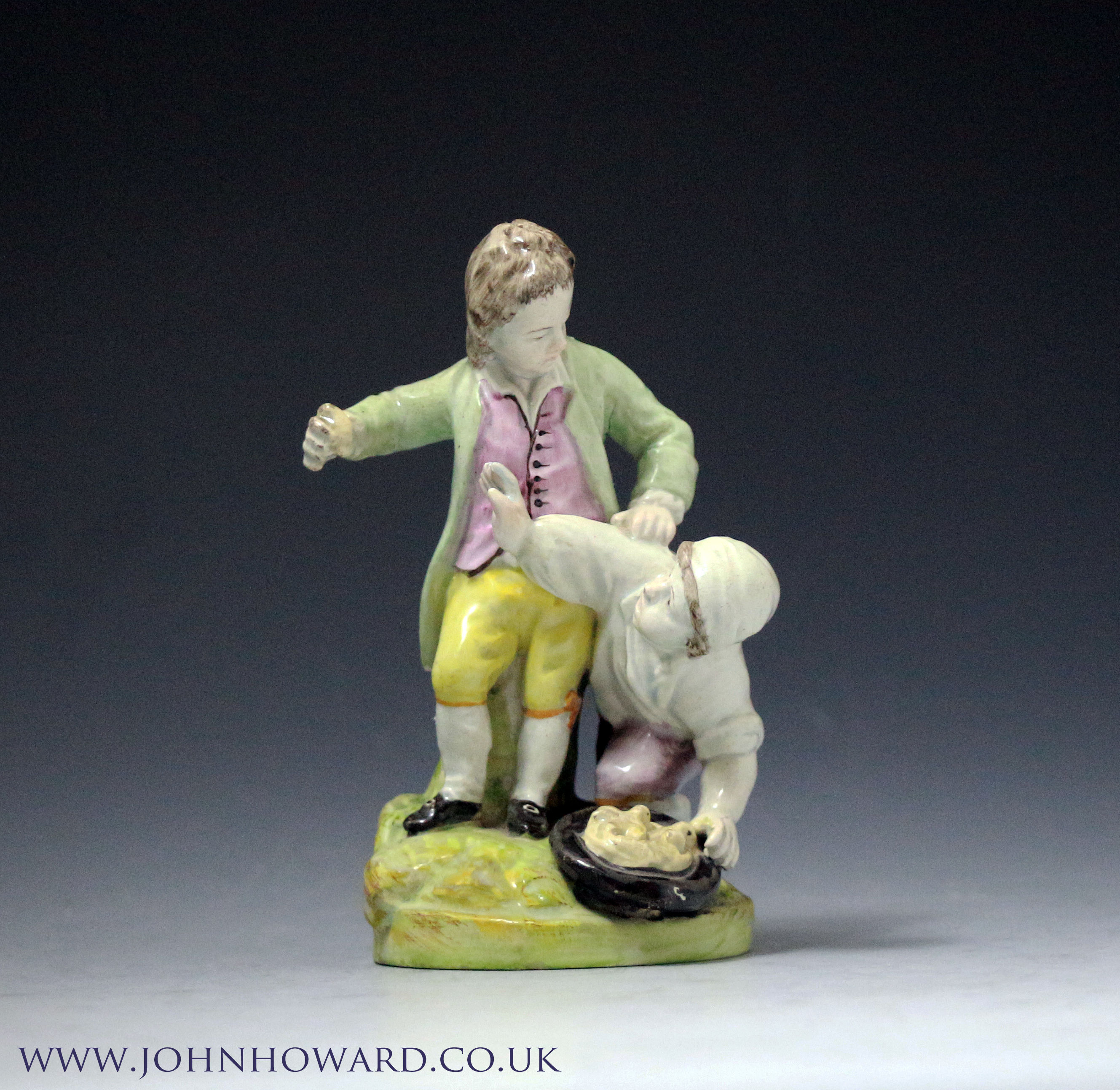 Staffordshire pottery figure group of two children scuffling over a birds nest. Antique period early 19th century