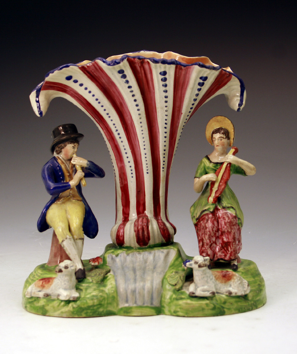 Staffordshire pottery figure group of musical shepherds by a stream